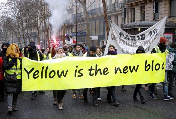 Protesters wearing yellow vests carry a banner in a demonstration by the "yellow vests" movement, in Paris, France, on Jan. 19, 2019. (Charles Platiau/Reuters)