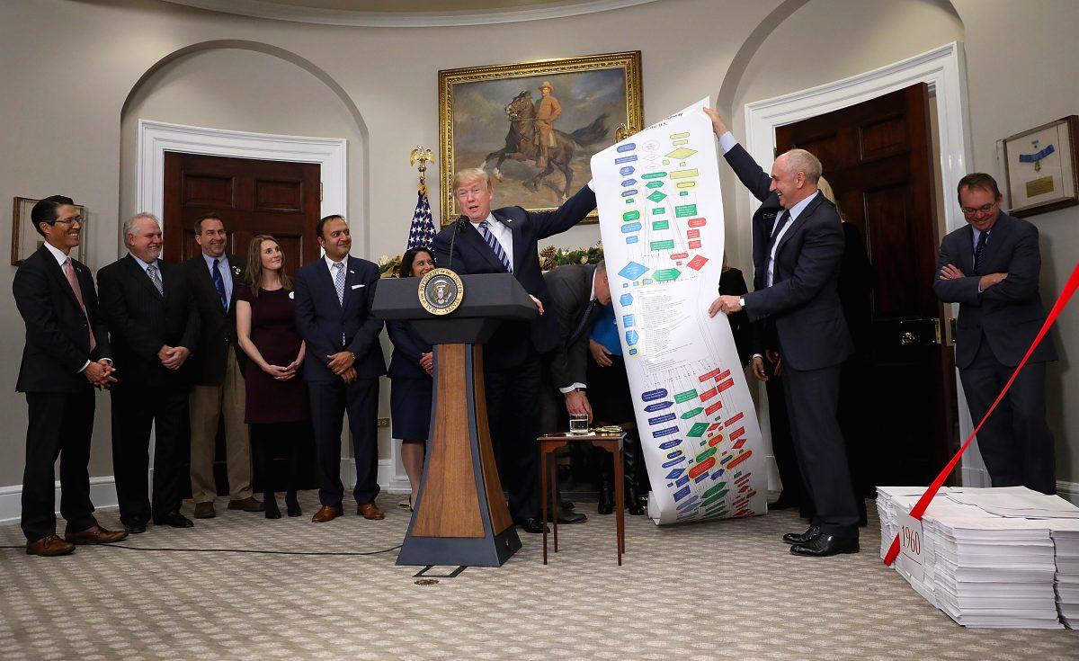 President Donald Trump holds a chart displaying regulations required to build infrastructure projects while speaking at an event at the White House promoting the administration's efforts to decrease federal regulations, on Dec. 14, 2017. (Win McNamee/Getty Images)
