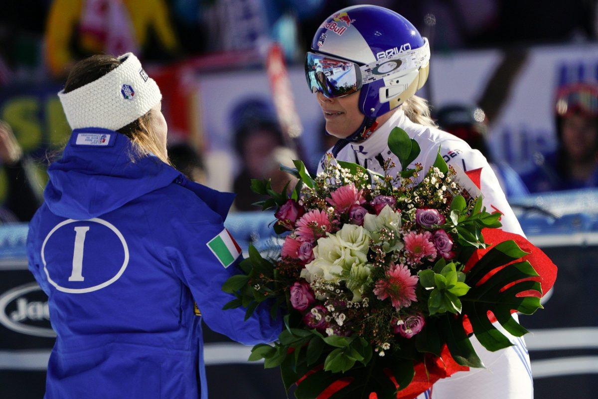 United States' Lindsey Vonn, right, receives a bunch of flowers from Italy's Sofia Goggia after completing an alpine ski, women's World Cup super-G in Cortina D'Ampezzo, Italy, on Jan. 20, 2019. (Giovanni Auletta/AP)