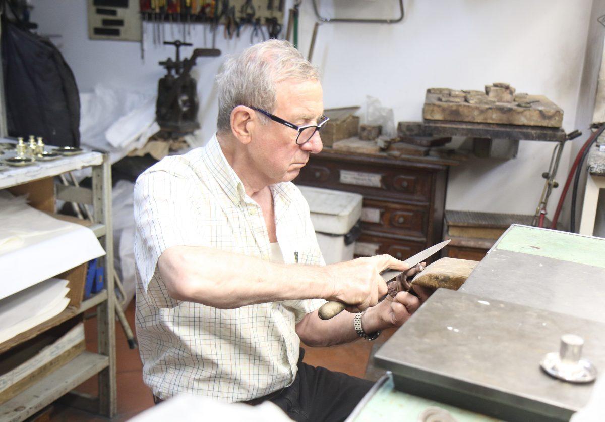 Paolo Pagliai files a bronze cherub in his workshop. (Lorraine Ferrier/The Epoch Times)