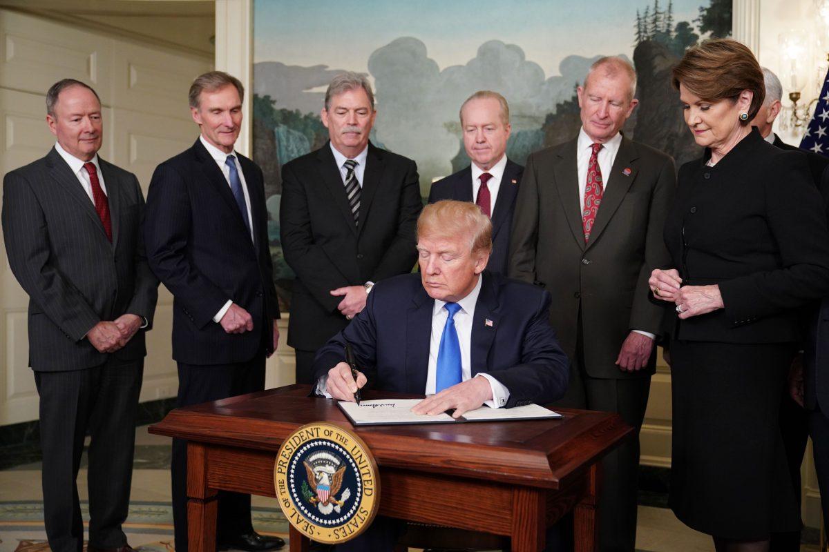 U.S. President Donald Trump signs trade sanctions against China in the Diplomatic Reception Room of the White House in Washington on March 22, 2018. The White House has said that Trump will impose tariffs on about $50 billion in Chinese goods imports to retaliate against the alleged theft of American intellectual property. (Mandel Ngan/AFP/Getty Images)