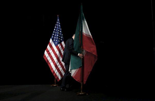 A staff member removes the Iranian flag from the stage during the Iran nuclear talks at the Vienna International Center in Vienna, Austria July 14, 2015. (Carlos Barria/Reuters)