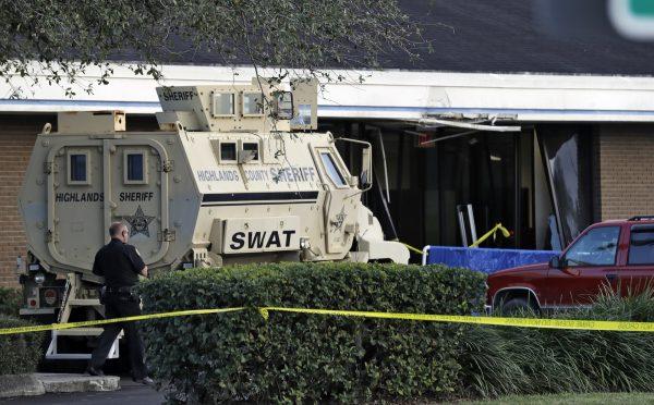 A police officer stands near a Highlands County Sheriff's SWAT vehicle that is stationed in front of a SunTrust Bank branch in Sebring, Fla. on Jan. 23, 2019. (Chris O’Meara/AP Photo)