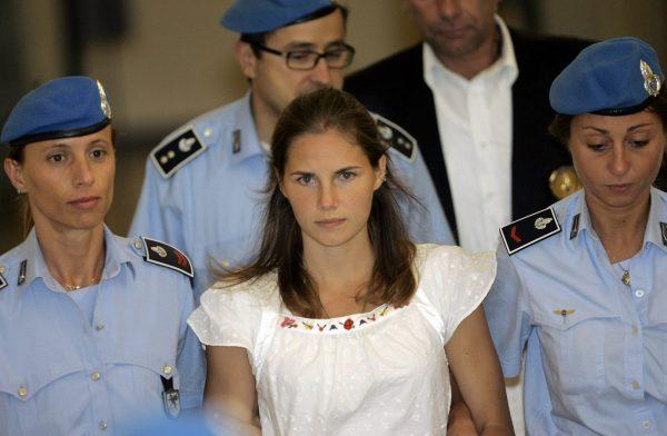 Amanda Knox, center, is escorted by Italian penitentiary police officers from Perugia's court after a hearing in central Italy, on Sept. 16, 2008. (Antonio Calanni, AP Photo, File)