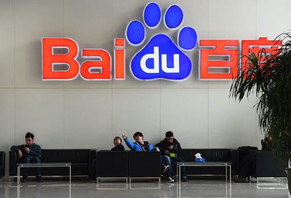 People sit below a Baidu logo at the Baidu headquarters in Beijing on Dec. 17, 2014. (Greg Baker/AFP/Getty Images)