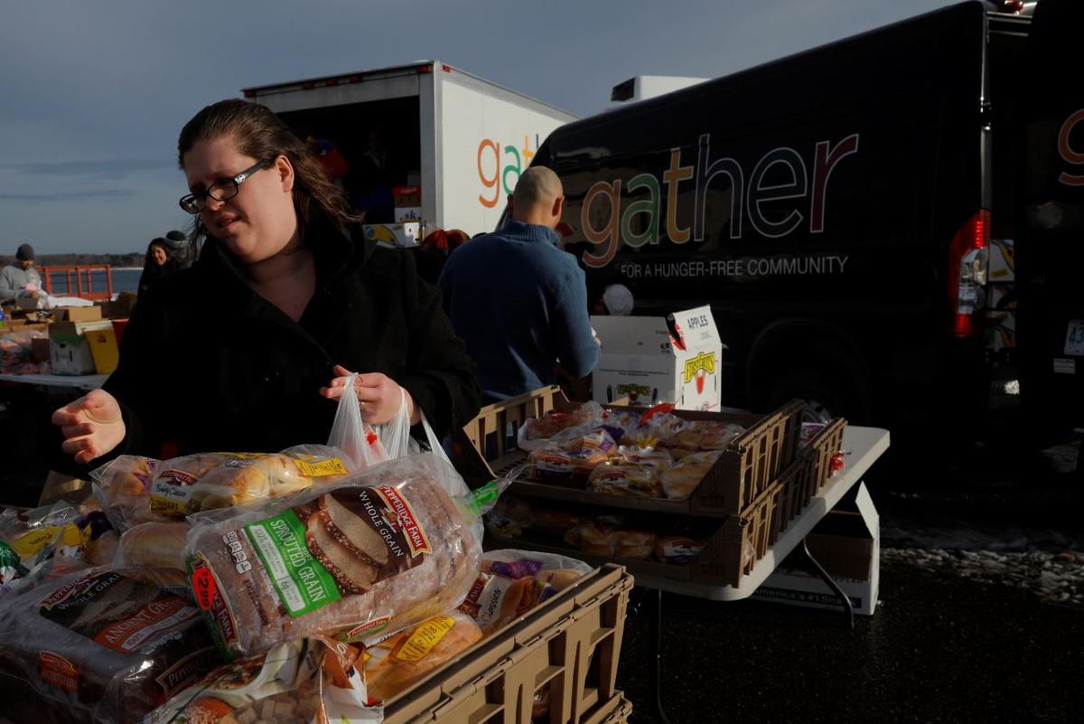Kera Myers, the wife of a member of the U.S. Coast Guard working without pay during the government shutdown, picks up produce, eggs, milk, bread and other supplies being distributed by Gather food pantry at the U.S. Coast Guard Portsmouth Harbor base in New Castle, New Hampshire, U.S., Jan. 23, 2019. (Reuters/Brian Snyder)