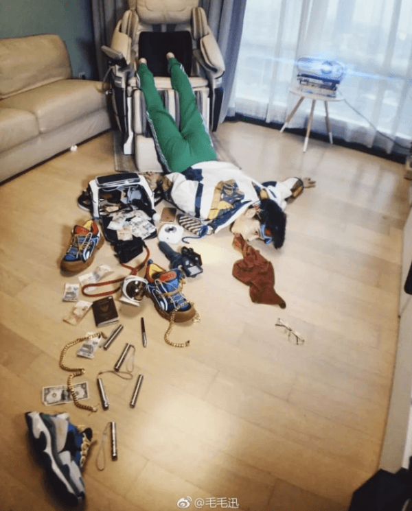 Man falls out of massage chair, spilling his belongings across the floor. (Screenshot via Weibo)