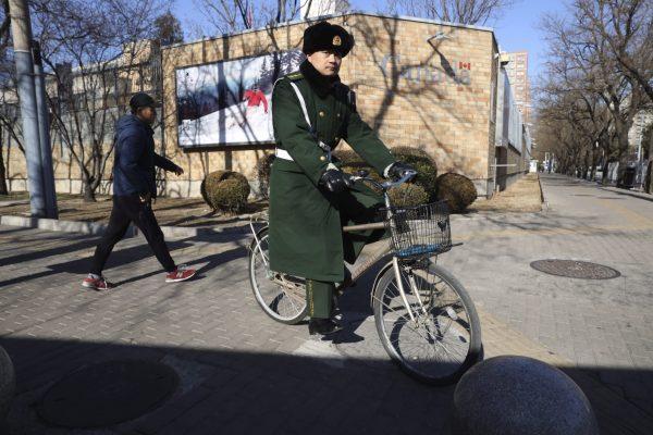 A Chinese paramilitary policeman rides past the Canadian Embassy in Beijing, China, on Jan. 16, 2019. (AP Photo/Ng Han Guan)