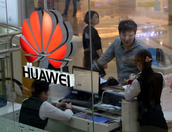 An employee uses a computer as she deals with a customer at a Huawei store in Beijing on March 24, 2014. Huawei has come under increasing scrutiny over allegations its products could be exploited by Beijing for spying. (Mark Ralston/AFP/Getty Images)