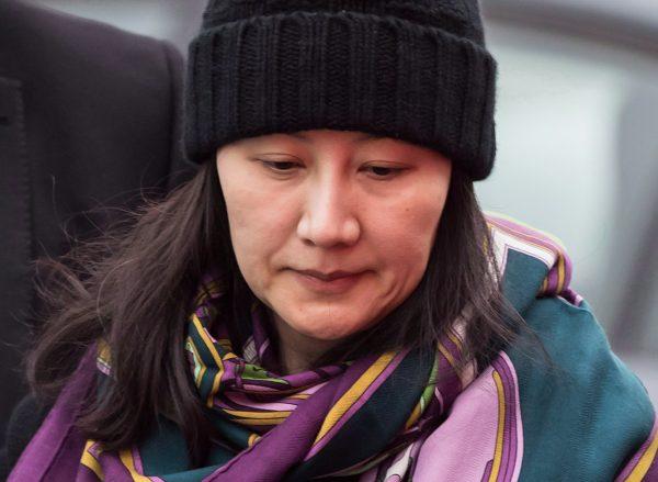 Huawei chief financial officer Meng Wanzhou is escorted by her private security detail while arriving at a parole office, in Vancouver, on Dec. 12, 2018. (The Canadian Press/Darryl Dyck)