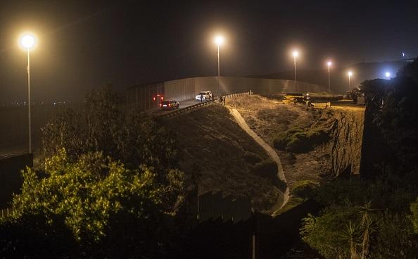 US border patrol agents search for Central American migrants hiding at the US-Mexico border fence in Playas de Tijuana, Baja California State, Mexico, on Nov. 30, 2018. (Pedro Pardo/AFP)