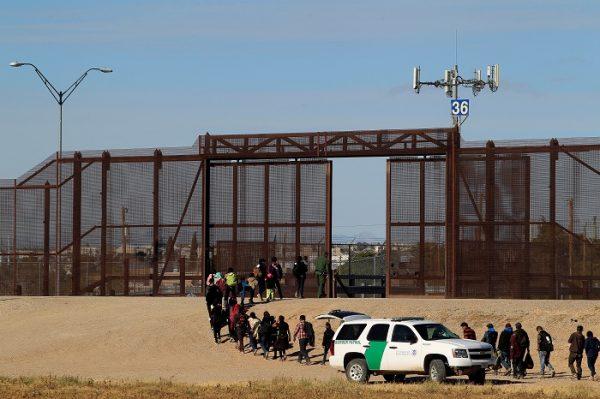 Illegal aliens from Central America are seen escorted by U.S. Customs and Border Protection (CBP) officials after crossing the border from Mexico to surrender to the officials in El Paso, Texas, on Dec. 3, 2018. (Jose Luis Gonzalez/Reuters)