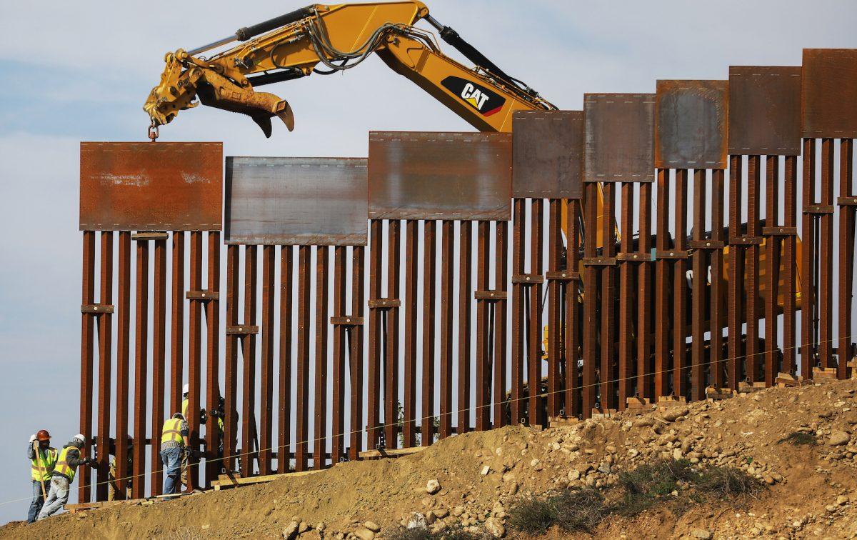 A construction crew installs new sections of the U.S.-Mexico border barrier replacing smaller fences as seen from Tijuana, Mexico, on Jan. 11, 2019. (Mario Tama/Getty Images)