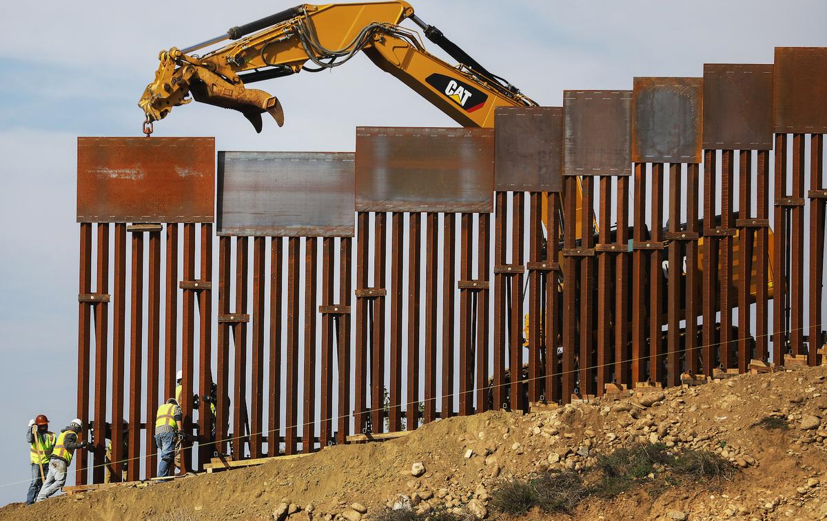 A construction crew installs new sections of the U.S.–Mexico border barrier replacing smaller fences on Jan. 11, 2019, as seen from Tijuana, Mexico. (Mario Tama/Getty Images)
