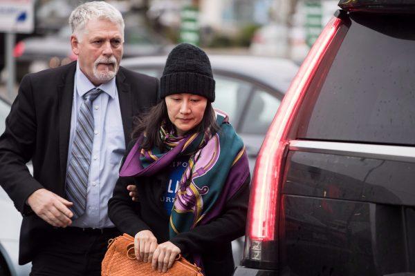 Huawei chief financial officer Meng Wanzhou, right, arrives at a parole office with a member of her private security detail in Vancouver, on Dec. 12, 2018. (Darryl Dyck/The Canadian Press)