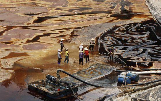 Workers drain away polluted water near the Zijin copper mine in Shanghang on July 13, 2010, after pollution from the mine contaminated the Ting River, a major waterway in southeast China’s Fujian Province. (STR/AFP/Getty Images)