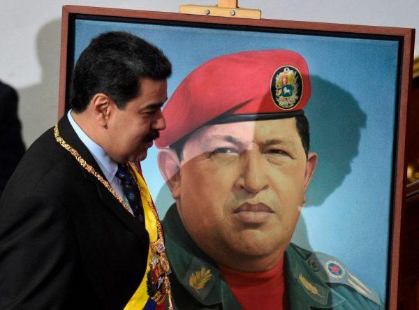 Venezuelan President Nicolás Maduro passes a portrait of late Venezuelan President Hugo Chávez in Caracas, Venezuela, on Jan. 14, 2019. (Federico Parra/AFP/Getty Images)