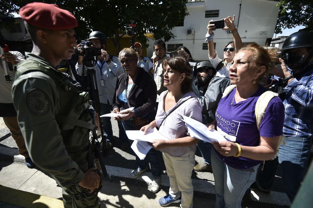 Supporters of Venezuela's National Assembly head and self-proclaimed "acting president" Juan Guaido distribute copies of amnesty measures to anyone in the military who disavows Nicolas Maduro, in Caracas on Jan. 27, 2019. (LUIS ROBAYO/AFP/Getty Images)