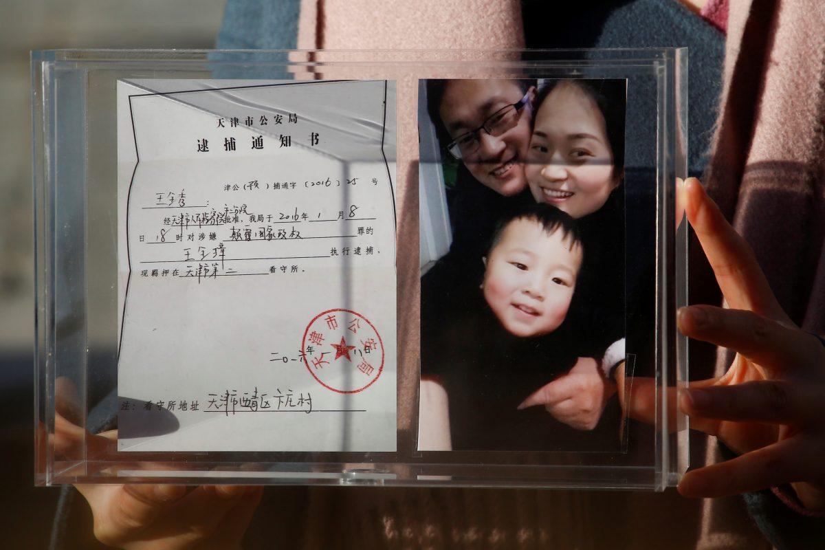 Li Wenzu, the wife of prominent Chinese rights lawyer Wang Quanzhang, holds a box with a family picture and the detention notice for her husband in Beijing on Dec. 17, 2018. (Thomas Peter/Reuters)