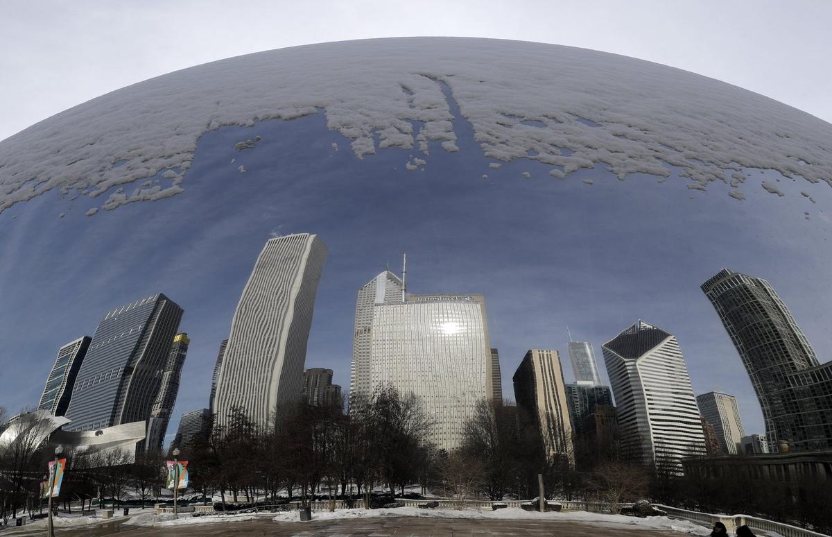 Reflections of a snowy city are seen in the 110-ton stainless steel Anish Kapoor sculpture called 'Cloud Gate' and nicknamed 'The Bean' at Millennium Park in Chicago, Sunday, Jan. 27, 2019. More than with many snowstorms Chicagoans have endured in recent history, where you live will greatly impact how much snow you arise to Monday morning, forecasters said. (AP Photo/Nam Y. Huh)