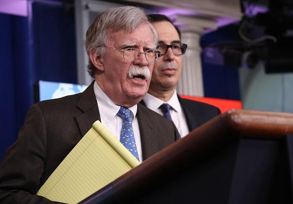 National Security Advisor John Bolton (L) and Treasury Secretary Steve Mnuchin (R) answer questions from reporters during a press briefing at the White House, in Washington, on Jan. 28, 2019. (Win McNamee/Getty Images)