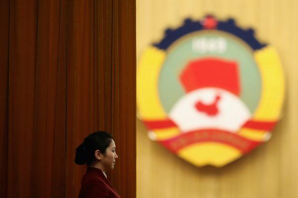 A hostess stands by the curtain as delegates enter the meeting room before the plenary session of the Chinese People's Political Consultative Conference at the Great Hall of the People in Beijing, China, on March 11, 2013. (Feng Li/Getty Images)