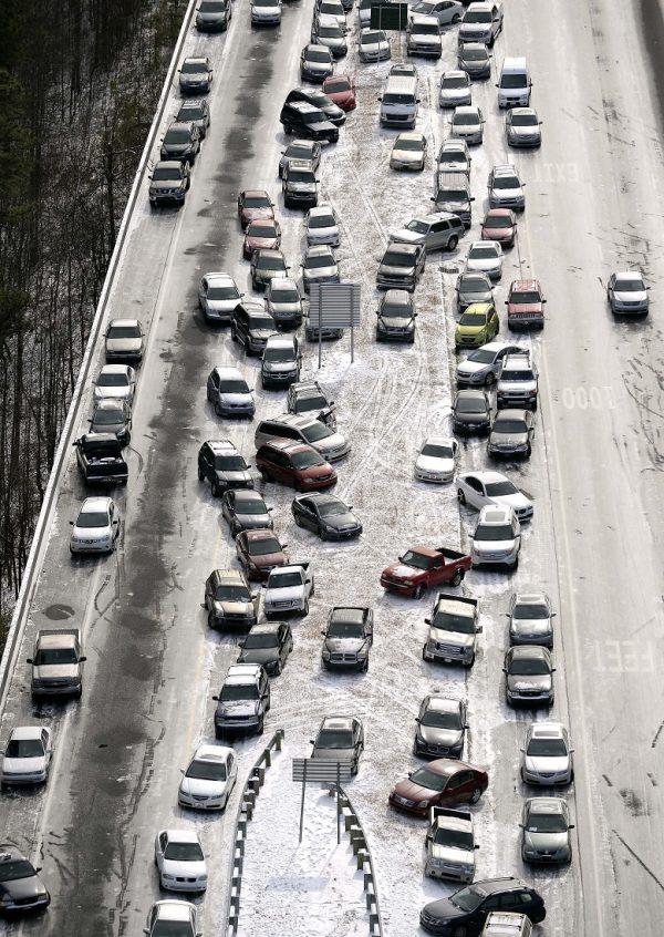 Abandoned cars at I-75 headed northbound near the Chattahoochee River overpass are piled up in the median of the ice-covered interstate after a winter snowstorm, in Atlanta on Jan. 29, 2014. (David Tulis/AP Photo)
