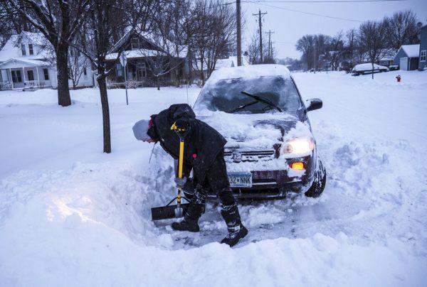 Adam Fischer shovels out his vehicle to go to work Monday, Jan. 28, 2019, in Rochester, Minn.  (Joe Ahlquist/The Rochester Post-Bulletin via AP)