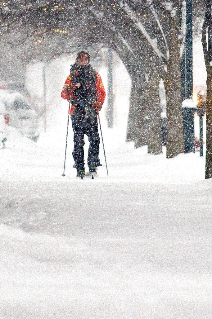 Mike Powers cross country skis to work in downtown Traverse City, Mich, as snow blankets the Grand Traverse area on Monday, Jan 28, 2019. (Jan-Michael Stump/Traverse City Record-Eagle via AP)
