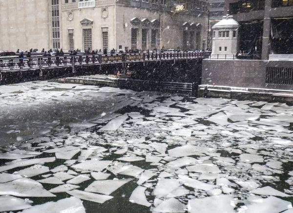 Pedestrians cross an icy Chicago River on Madison St. near the Civic Opera House in Chicago on Jan. 28, 2019. (Rich Hein/Chicago Sun-Times via AP)