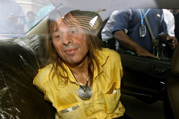 Alain Robert in a police car after being arrested for climbing the landmark Petronas Twin Towers in downtown Kuala Lumpur, March 20, 2007. (Tengku Bahar/AFP/Getty Images)