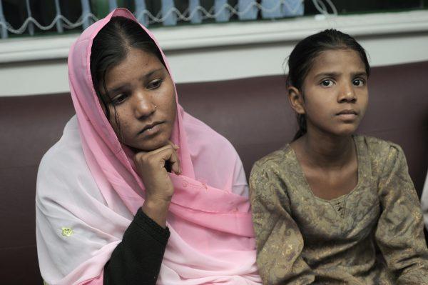 Sidra (L) and Esham, the daughters of Aasia Bibi, a Christian mother sentenced to death, listen to Pakistani Minister of Minority Affairs Shahbaz Bhatti in Islamabad on Nov. 24, 2010. (Farooq Naeem/AFP/Getty Images)