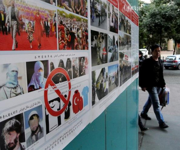 Pedestrians walk past anti-terror propaganda posters pasted along the streets of Urumqi, farwest China's Xinjiang region, on Sept. 16, 2014.(GOH CHAI HIN/AFP/Getty Images)