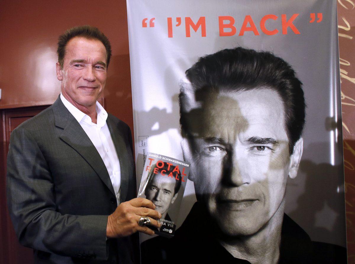 US actor and former California governor Arnold Schwarzenegger holds his autobiography entitled "Total Recall" after a press conference in Paris on Oct. 12, 2012. (Patrick Kovarik/AFP/Getty Images)