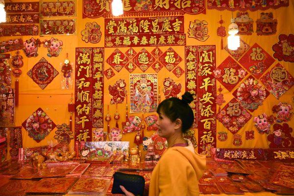A woman walking past a wall decorated with new year couplets at a traditional market on Di Hua street to mark the coming Lunar New Year—the Year of the Pig—in Taipei on Jan. 25, 2019. (Sam Yeh/AFP/Getty Images)