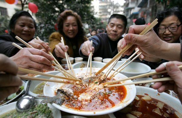 Friends dine on a feast to celebrate Chinese New Year during a community activity in Chengdu, Sichuan Province, China on Jan. 14, 2006. (China Photos/Getty Images)