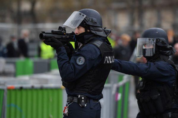 A police officer holds a non-lethal hand-held weapon during a 'yellow vest' protest in Paris on Jan. 26, 2019. (Christophe Archambault/AFP/Getty Images)