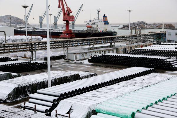 A cargo ship is seen behind snow-covered steel pipes at a port in Lianyungang, Jiangsu Province, China on Jan. 31, 2019. (Reuters)