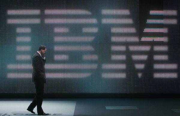 A fairgoer speaks on his mobile phone in front of a giant IBM logo at the CeBIT trade fair in Hanover, Germany on March 5, 2008. (JOHN MACDOUGALL/AFP/Getty Images)