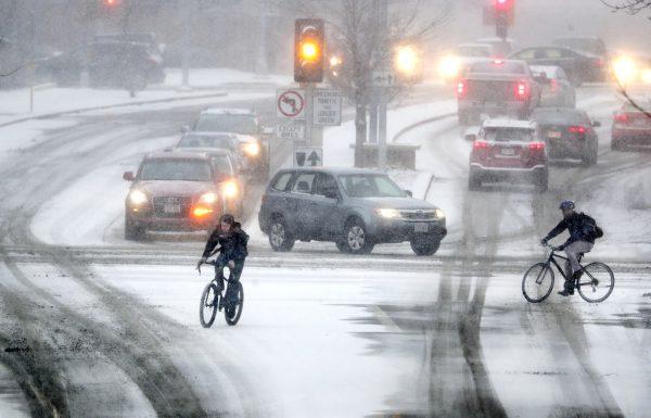 Bikers crossing Park Street at the intersection of University Ave during a late afternoon snowstorm in Madison, Wis., on Jan. 18, 2019. (Steve Apps/Wisconsin State Journal via AP)
