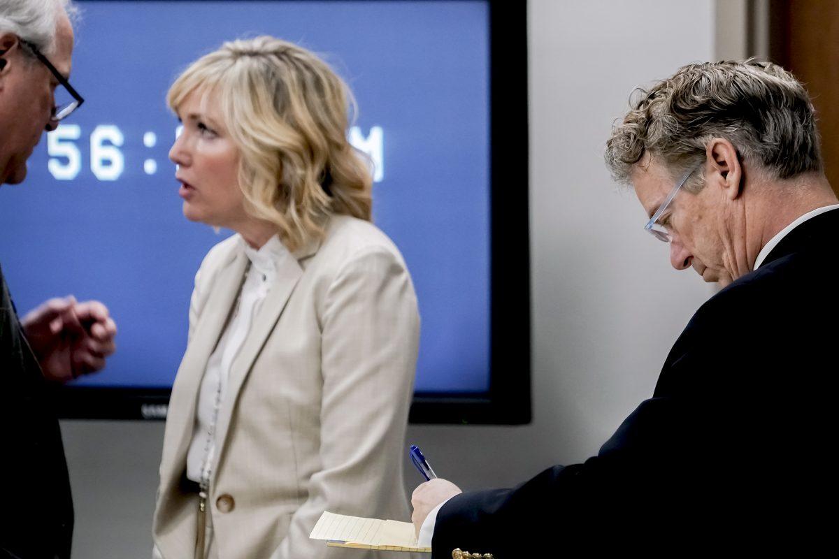 U.S. Sen. Rand Paul (R-Ky.) makes notes as his wife, Kelley Paul, talks with Paul's attorney, Tom Kerrick, during the second day of a civil trial involving Paul and his neighbor, Rene Boucher, in Warren Circuit Court in Bowling Green, Kentucky, on Jan. 29, 2019. (Bac Totrong/Daily News via AP)
