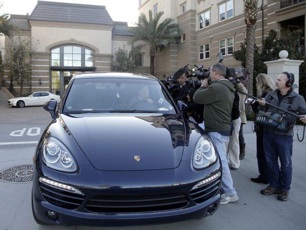 Resident Jin-Jou Lu sits in his vehicle while talking to reporters outside after federal agents raided an upscale apartment complex where authorities say a birth tourism business charged pregnant women $50,000 for lodging, food and transportation, in Irvine, California, U.S. on March 3, 2015. (Jae C. Hong/AP)