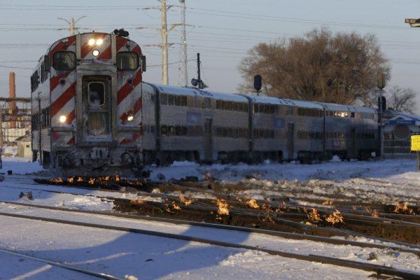 A Metra train moves southbound to downtown Chicago as the gas-fired switch heater on the rails keeps the ice and snow off the switches near Metra Western Avenue station in Chicago, on Jan. 29, 2019. (Kiichiro Sato/AP Photo)
