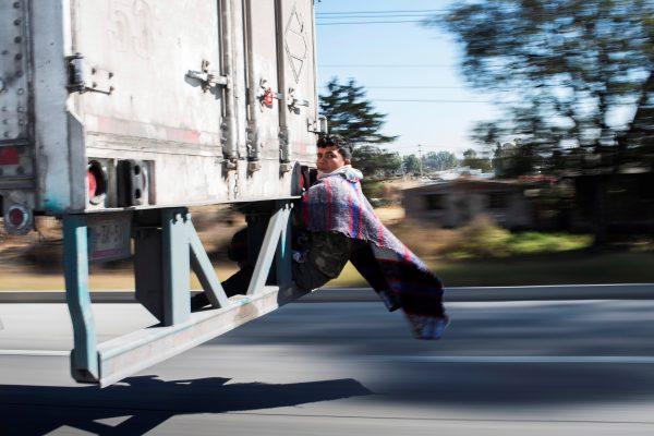 Migrant Javier Gomez, from Honduras, takes a lift in the back of a truck during his journey towards the United States, in Mexico City, Mexico, Jan. 31, 2019. (Alexandre Meneghini/Reuters)