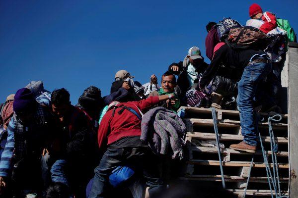 Migrants climb the back of a truck during their journey towards the United States, in Mexico City, Mexico, on Jan. 31, 2019. (Alexandre Meneghini/Reuters)