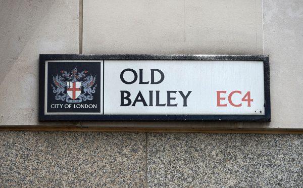 The coat of arms of the City of London (L) is pictured on the street sign for "Old Bailey", where the Central Criminal Court, commonly referred to as The Old Bailey, is situated in central London on Aug. 21, 2016. (Niklas Halle'n/AFP/Getty Images)