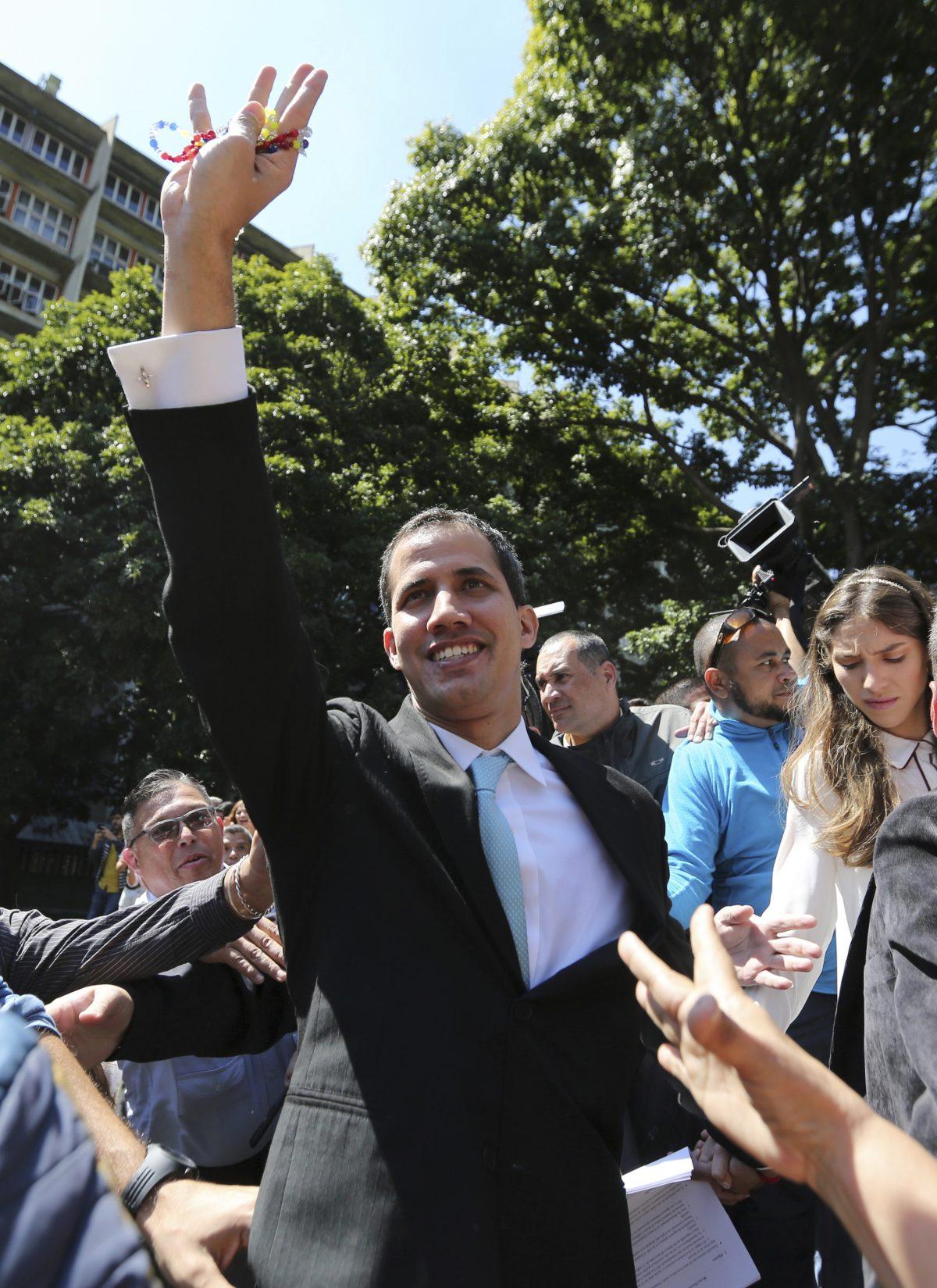 Opposition National Assembly President Juan Guaido greets supporters upon his arrival to the Venezuelan Central University for a conference on economic plans for reviving the country in Caracas, Venezuela, Jan. 31, 2019. An independent U.N. human rights monitor says economic sanctions are compounding a "grave crisis" in Venezuela. (AP/Fernando Llano)