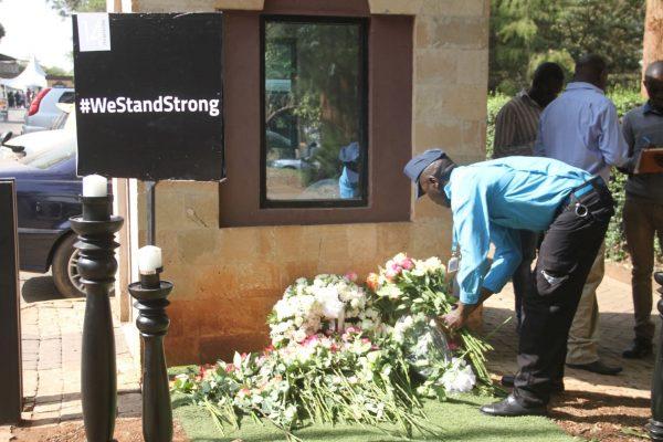 A security guard places flowers at a memorial for the victims who perished during the attack on the DusitD2 hotel complex in Nairobi, Kenya, on Jan. 15, 2019. (Dominic Kirui/Special to The Epoch Times)