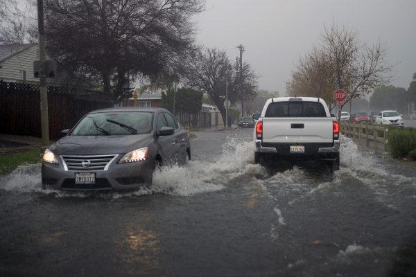 Vehicles make their way through flooded streets of Panorama City section of the San Fernando Valley in Los Angeles Saturday, Feb. 2, 2019. (Richard Vogel/AP)