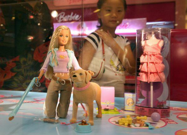 A young Chinese girl looks at a "Barbie and Tanner" toy made by US toy giant Mattel, which is still for sale in China despite being recalled in the US, at a department store in Shanghai, 15 August 2007. According to the commission, the play sets' "scooper" accessory has a small magnet that can come loose. (Mark Ralston/AFP/Getty Images)